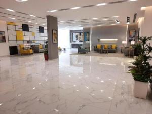 a lobby with a large marble floor and yellow chairs at شقق الآجنحة التنفيذية للشقق المخدومة in Riyadh