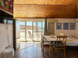 a kitchen and dining room with a table and chairs at LaRos Apt in Herceg-Novi