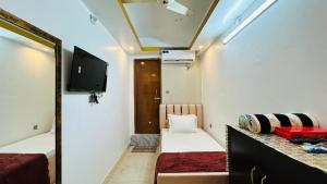 a small room with a bed and a mirror at Hotel New Kalabagan in Dhaka