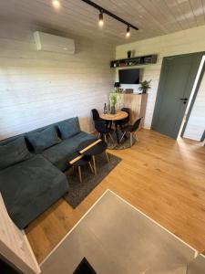 a living room with a blue couch and a table at Domki u Izabeli niedaleko Darłowa in Rusko