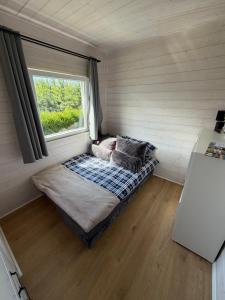 a bed in a room with a window at Domki u Izabeli niedaleko Darłowa in Rusko +5 photos