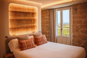 a bedroom with a white bed with a window at La Venta de Bodegas Ostatu in Samaniego