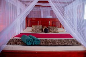 a bedroom with a canopy bed with pillows and blankets at Little Pumpkin Cabanas & seafood restaurant in Tangalle