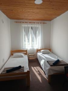 two beds in a room with a window at Natasa in Bačka Palanka