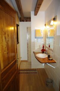 a bathroom with a sink and a wooden door at Ecrin du Ségala - Chambres d'hôtes in Tauriac-de-Naucelle