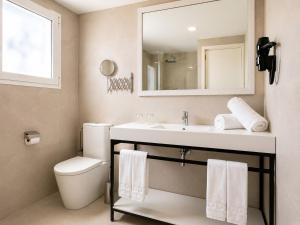 a bathroom with a sink and a toilet and a mirror at Cabot Sivella Apartments in Port de Pollensa