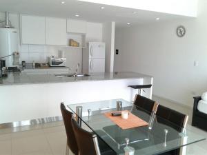 a kitchen with a glass table with chairs and a counter at Balcones de Tandil Departamentos in Tandil