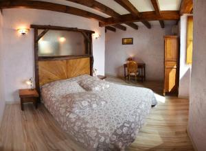 a bedroom with a large bed and a table at Ecrin du Ségala - Chambres d'hôtes in Tauriac-de-Naucelle
