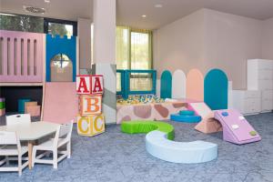 a playroom with a table and chairs and a play area at Family Hotel Adria - All inclusive in Biograd na Moru
