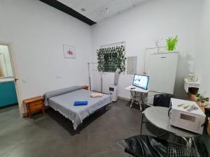 a bedroom with a bed and a desk with a computer at Casa OASIS in Almonte