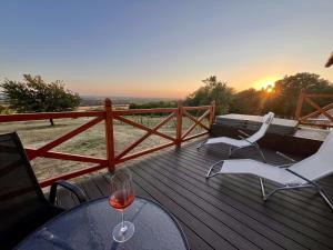 a glass of wine sitting on a deck with a table and chairs at Odavagyok Vendégház in DiÃ³sviszlÃ³
