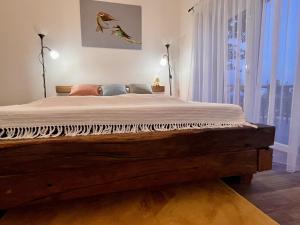 a bedroom with a wooden bed with a window at Odavagyok Vendégház in DiÃ³sviszlÃ³