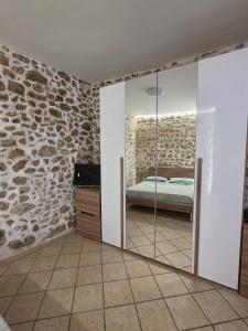 a bedroom with a stone wall and a mirror at Cavour 92 in Alatri