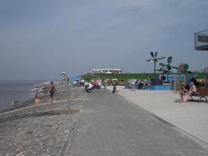 a group of people walking on the beach at Nordseeferienbungalow in Butjadingen