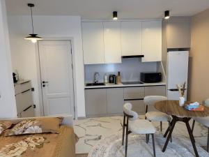 a kitchen with white cabinets and a table and chairs at Ugam Mountain apartments in Khumson