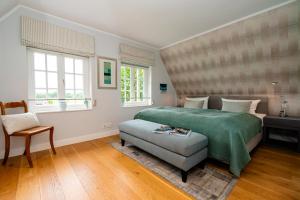 a bedroom with a bed and a chair and windows at LITZKOW 14205 in Morsum
