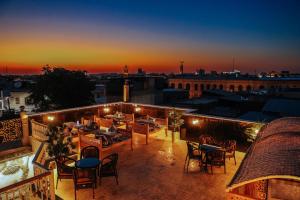a rooftop patio with tables and chairs at sunset at Aida hotel PREMIUM in Bukhara