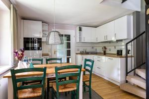 a kitchen and dining room with a wooden table and chairs at Meermaler in Ahrenshoop