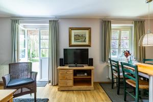a living room with a television on a wooden table at Meermaler in Ahrenshoop