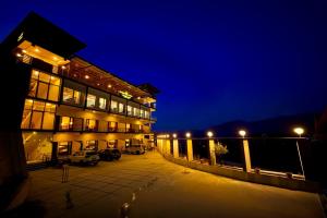 a building with a lot of windows at night at The kempty Fall Resort, Mussoorie - Lavish & Luxury Stay in Mussoorie