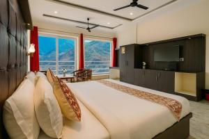a bedroom with a large bed and a television at The kempty Fall Resort, Mussoorie - Lavish & Luxury Stay in Mussoorie
