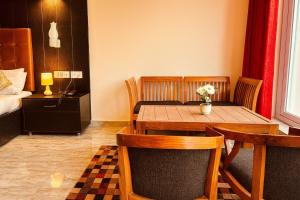 a room with a table and chairs and a bed at The kempty Fall Resort, Mussoorie - Lavish & Luxury Stay in Mussoorie