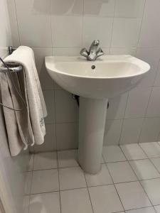a white sink in a bathroom with towels at Manuella Hotel in Ed Dkârîne +18 photos