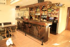 a bar with a lot of bottles of alcohol at Manuella Hotel in Ed Dkârîne