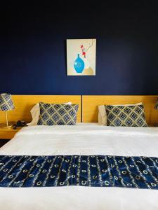 a bedroom with a bed with a blue wall at Manuella Hotel in Ed Dkârîne