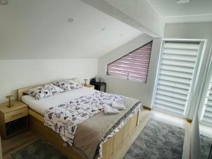 a bedroom with a bed and a large window at Vikendica Teodora - Zvornik in Zvornik