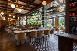 ein Restaurant mit Tischen und Stühlen und einem großen Fenster in der Unterkunft Hotel Kraft in Kraśnik