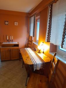 a dining room with a wooden table and a kitchen at Malwers in Zielonka