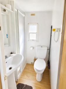 a white bathroom with a toilet and a sink at Camping Nysa Paziols in Paziols +45 photos