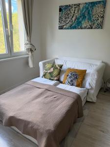 a white couch with pillows in a room with a window at Apartmánový byt VYHNE in Vyhne