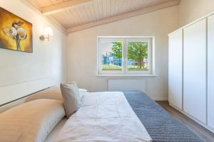 a bedroom with a large bed with a window at Ferienhaus Süderoog in Dagebüll