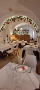 ein Restaurant mit weißen Tischen und Stühlen und einem Torbogen in der Unterkunft Dimora Intini in Noci
