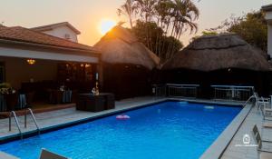 a swimming pool in front of a house at Hotel Lubumbashi Golf in Lubumbashi