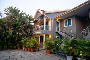 a house with a bunch of plants in front of it at Hotel Lubumbashi Golf in Lubumbashi