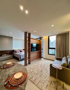 a living room with a couch and a bed at Neo House in Maringá