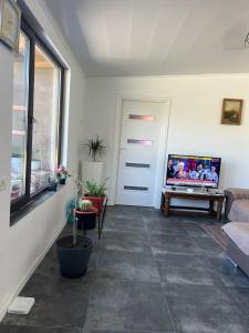 a living room with a couch and a tv on the wall at Casa Rodica in Mangalia