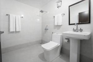 a white bathroom with a toilet and a sink at The Spring Dale Resort, Mussoorie by Sitara group - Best Selling Resort in Mussoorie 2025-26 in Mussoorie
