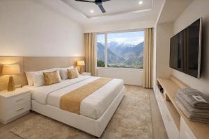 a bedroom with a large bed and a large window at The Spring Dale Resort, Mussoorie by Sitara group - Best Selling Resort in Mussoorie 2025-26 in Mussoorie