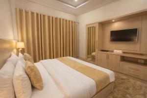 a hotel room with a bed and a flat screen tv at The Spring Dale Resort, Mussoorie by Sitara group - Best Selling Resort in Mussoorie 2025-26 in Mussoorie +20 photos