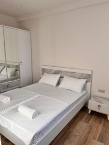 a bedroom with a large white bed with a mirror at Your Cozy Home 2BR Local Vibe 25 Mins to Center in Yerevan