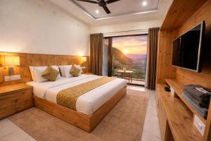 a bedroom with a large bed and a large window at The Spring Dale Resort, Mussoorie by Sitara group - Best Selling Resort in Mussoorie 2025-26 in Mussoorie