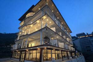 a large building with lights on it at night at The Spring Dale Resort, Mussoorie by Sitara group - Best Selling Resort in Mussoorie 2025-26 in Mussoorie