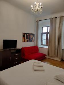a living room with a red couch and a window at Casa Sforii Brasov in Braşov