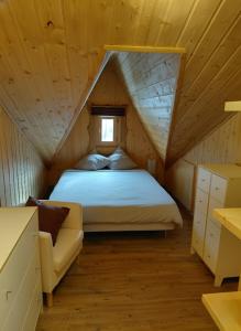 a bedroom with a bed and a couch in a attic at La Tapia in La Foux d'Allos