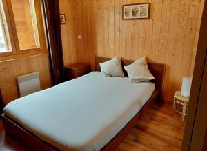 a bedroom with a bed in a wooden room at La Tapia in La Foux d'Allos +4 photos