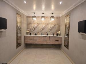 a bathroom with two sinks and a painting on the wall at Sunrise Serenity Guest House in Lydenburg